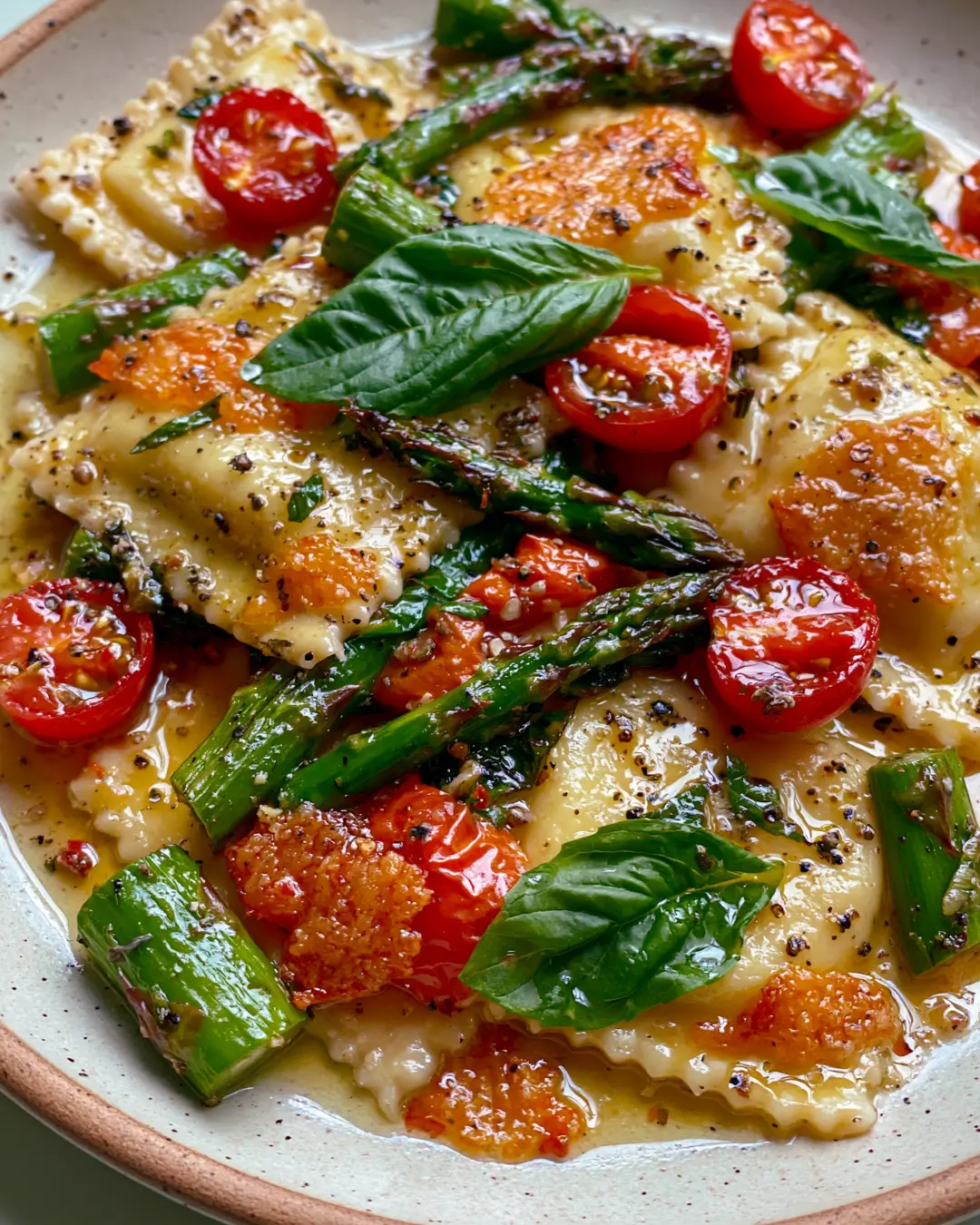 Garlic Butter Ravioli with Asparagus, Blistered Tomatoes, Basil & Crispy Parmesan