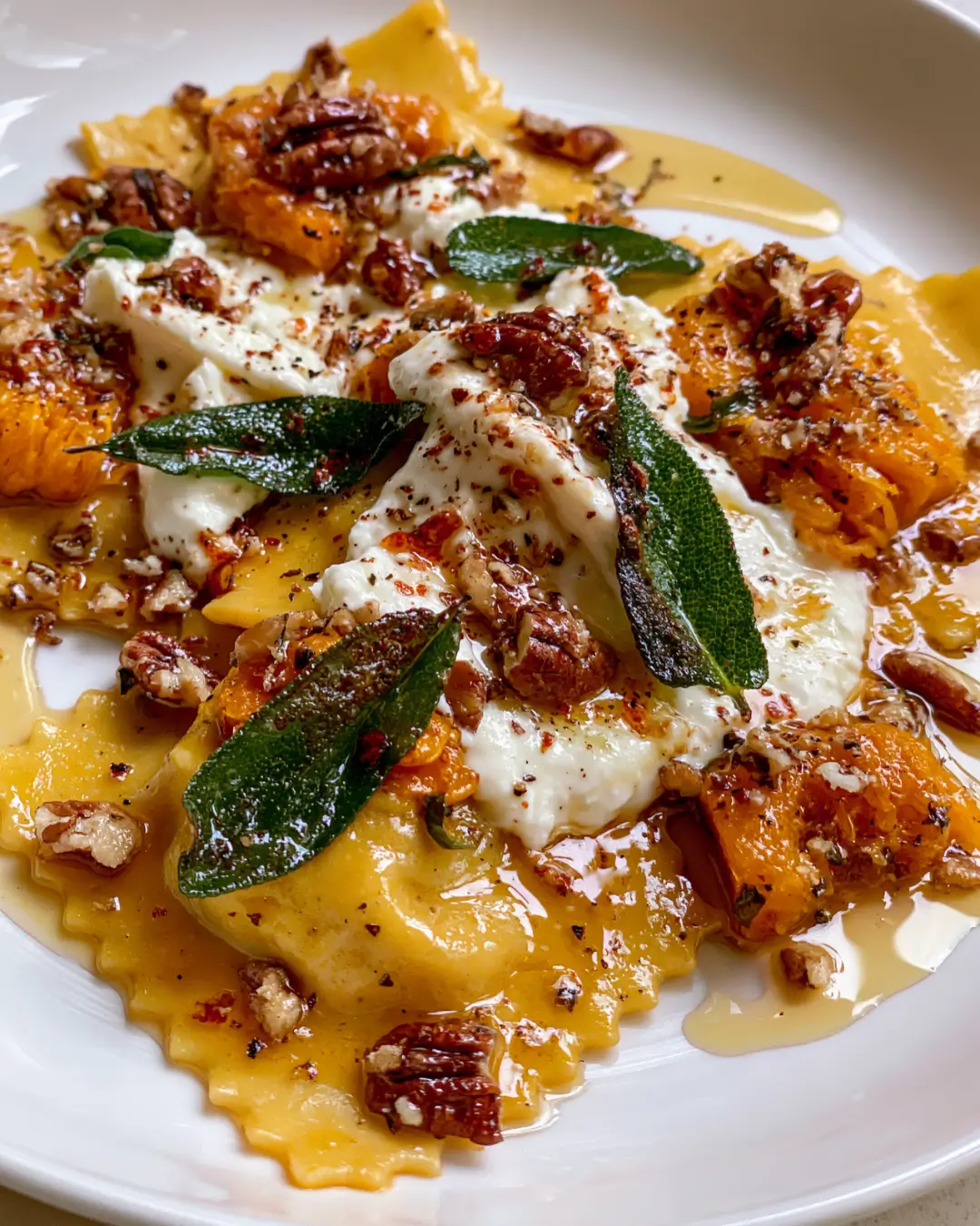 Roasted Butternut Squash Ravioli with Crispy Sage, Burrata, Pecans & Hot Honey